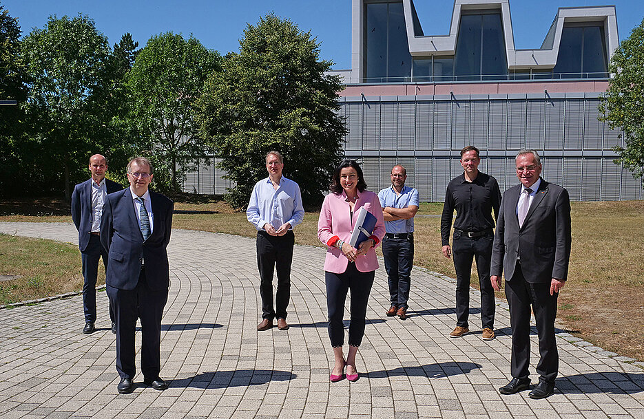 Universitätspräsident Alfred Forchel und Staatsministerin Dorothee Bär mit den Teilnehmern des Treffens, bei dem das neue Zentrum CAIDAS vorgestellt wurde.