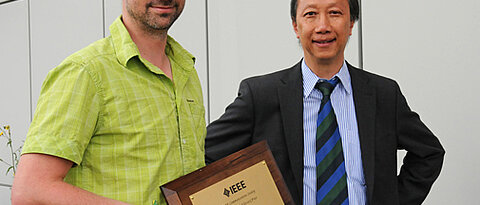 Die Würzburger Informatiker Tobias Hoßfeld (links) und Phuoc Tran-Gia mit der Auszeichnung, die sie von der IEEE Communications Society bekommen haben. (Foto: Robert Emmerich)