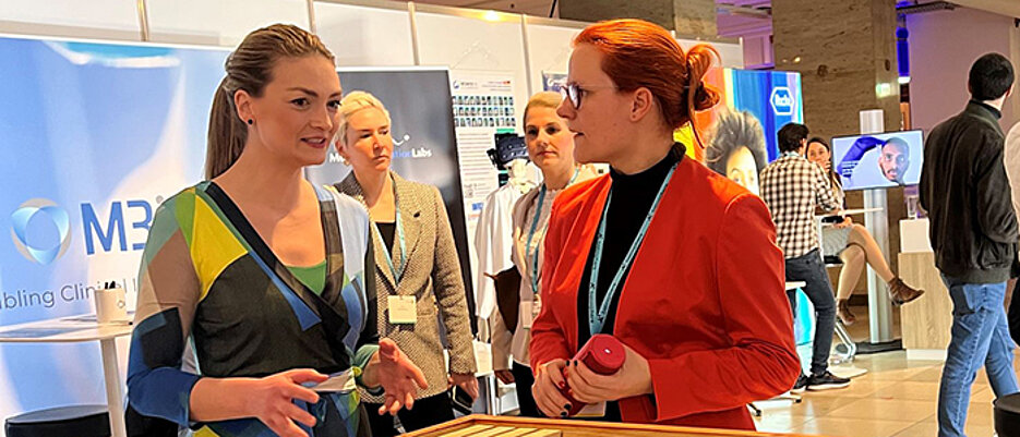 Bayerns Digitalministerin Judith Gerlach (l.) informierte sich auf der Messe ai.bay bei we4bee-Mitarbeiterin Anna Krause über die intelligenten Bienenstöcke.